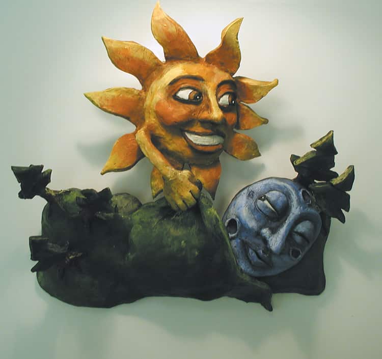 A clay sculpture showing a sun tucking the moon into bed